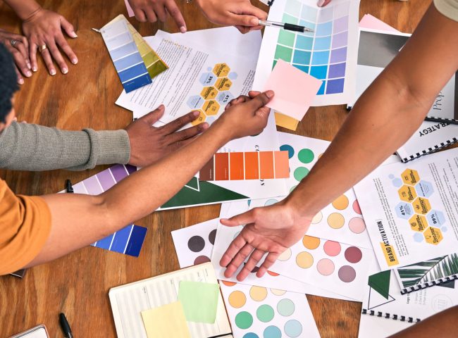 Color, design palette and hands of business people on desk for branding meeting, strategy and marke.